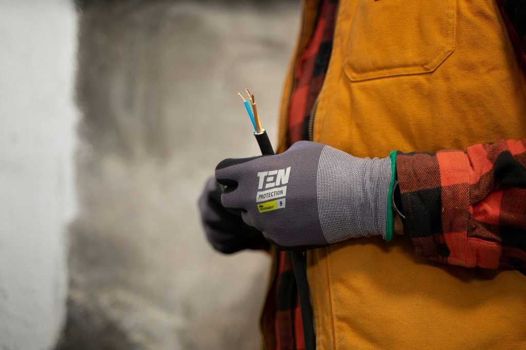 Osoba trzyma w ręku przewód instalacji elektrycznej z widocznymi żyłami